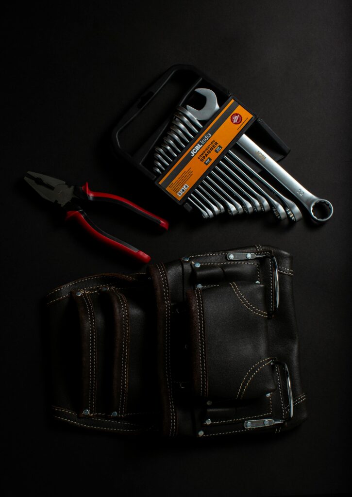 Premium hand tools and leather tool belt arranged on a dark surface. Ideal for projects.